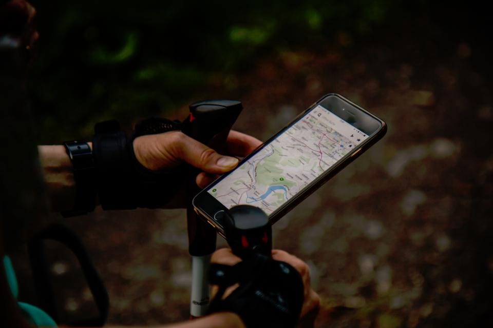 A phone held on handlebars showing a street map
