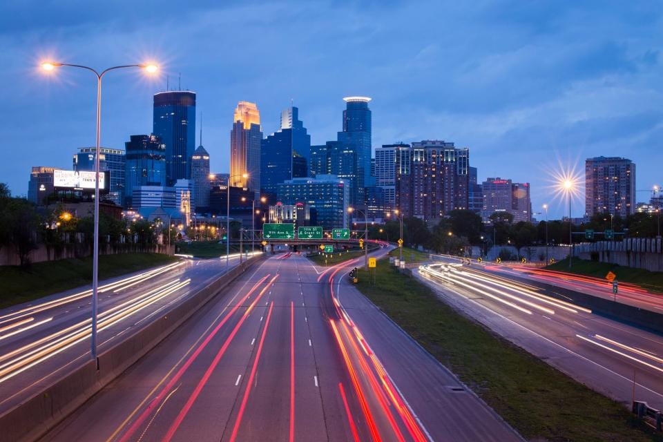 City traffic at dusk, headlights drawn into light trails