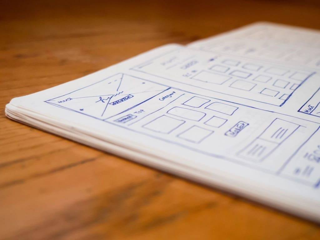 Website wireframes sketched in pen in a notebook